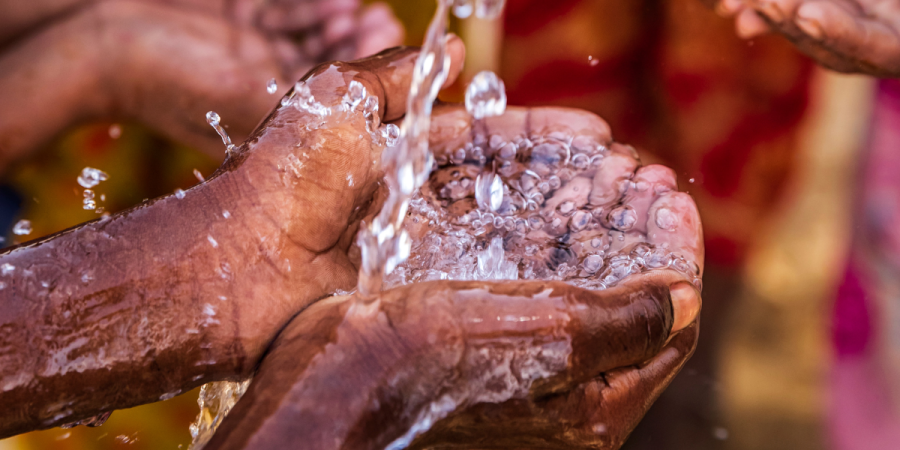 a closeup of water falling on to open palms