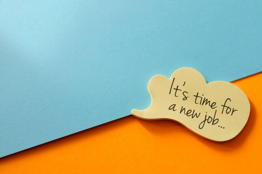A yellow sticky note reading, 'Time for a new job' against a blue-orange backdrop