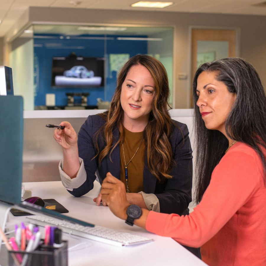 two female colleagues pointing to a screen