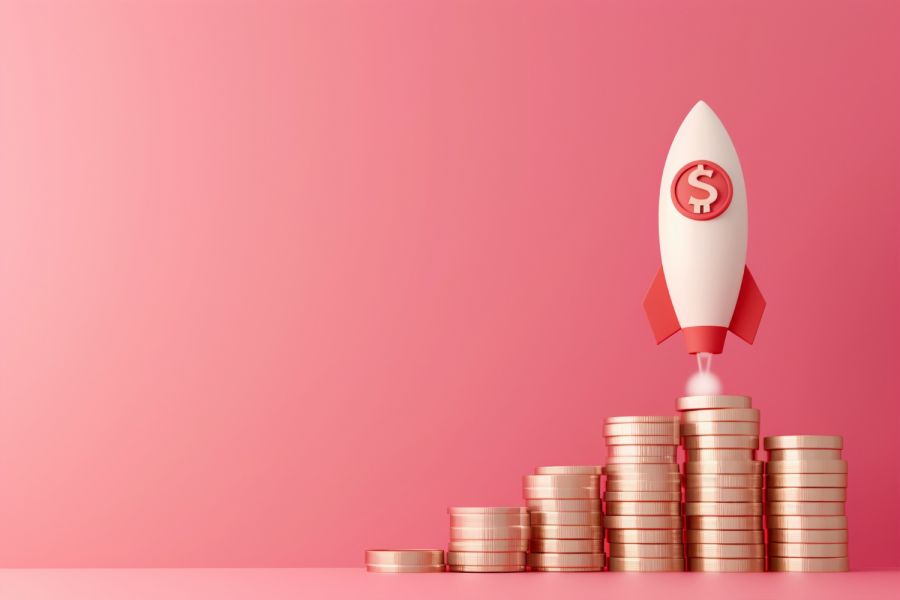 Concept image of rocket and coins on pink background