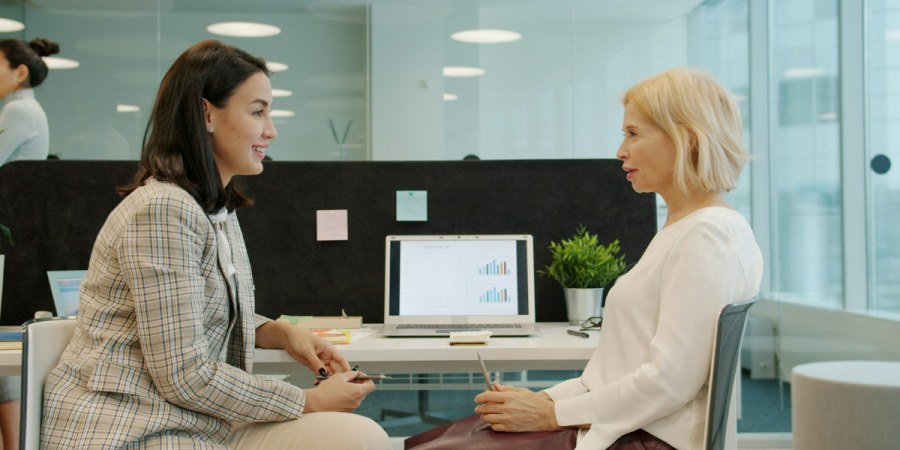 two women discussing data at their desks