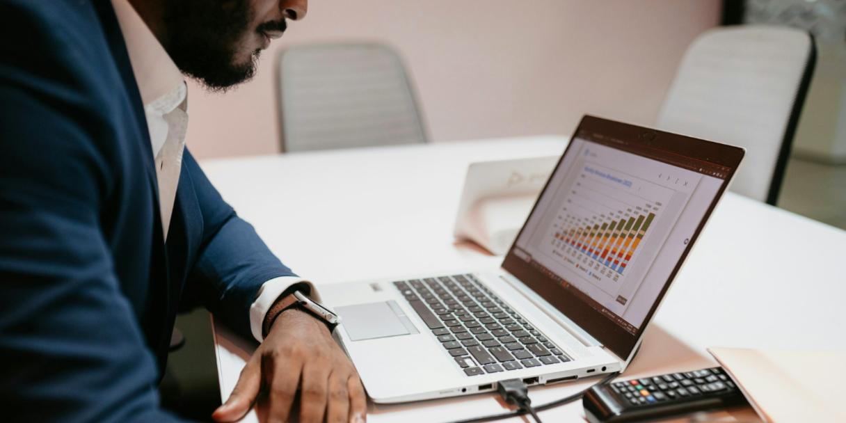 male accountant studying bar charts on laptop