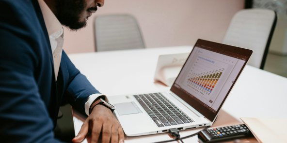 male accountant studying bar charts on laptop
