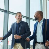 Two businessmen walking through a departures airport terminal