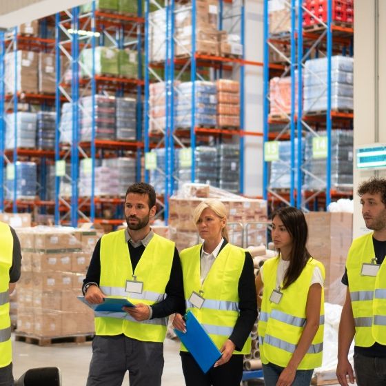 A warehouse team of men and women in forklifting training