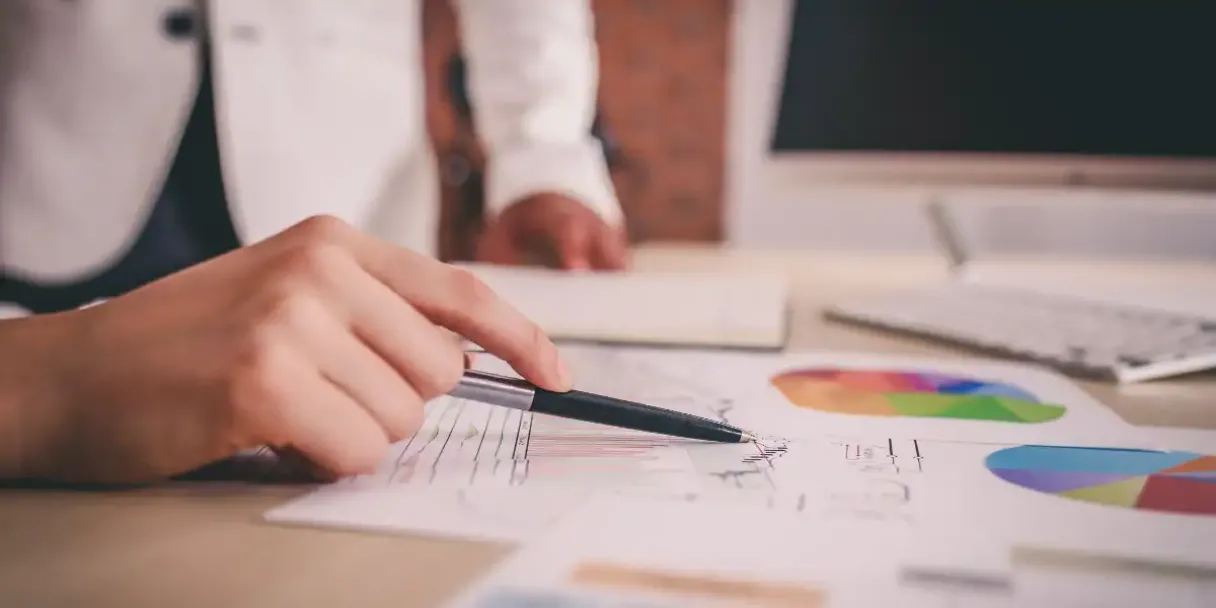 a closeup of a hand holding a pen while examining stats