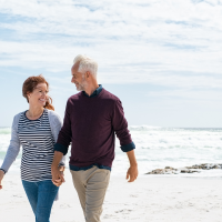 mature retired couple walking on the beach