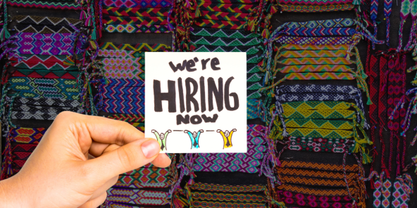 Colourful woven bracelets with a 'We're hiring' signpost
