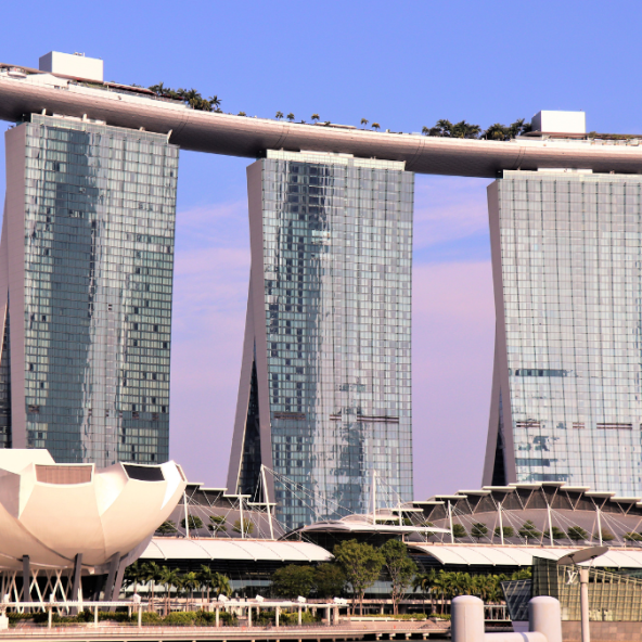 the Marina Bay Sands hotel in Singapore, a resort with three towers connected by a sky-top infinity pool, overlooks a bay filled with many ships