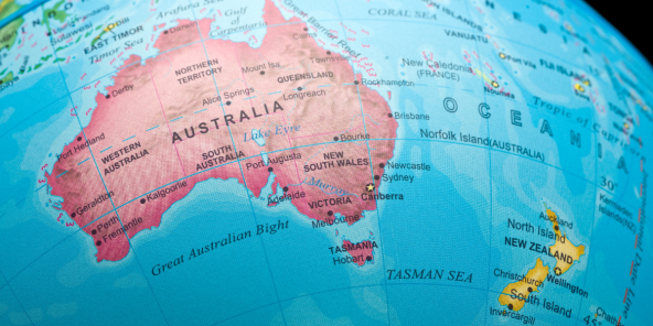 A blue world map focused on Australia, showing surrounding oceans and nearby islands, with labelled regions and borders on a globe-like projection.