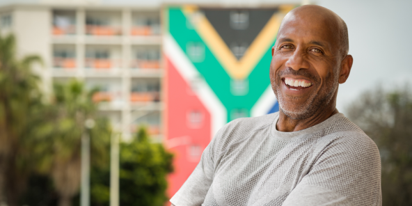 mature smiling man in front of the south african flag