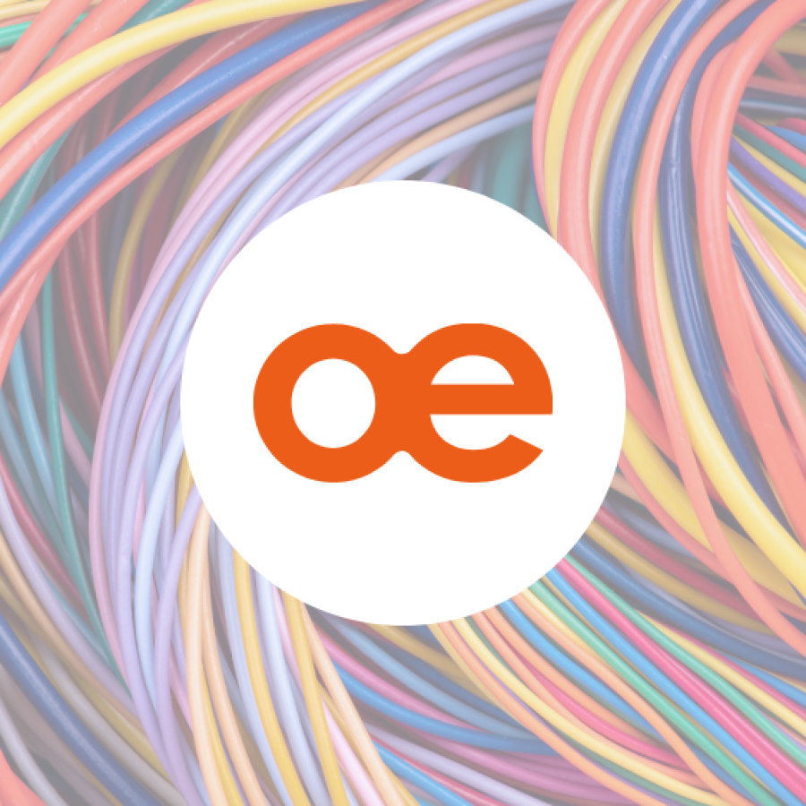 Close-up of tightly bundled multicoloured electrical cables and wires, curving and looping together in dense rows against a dark background.