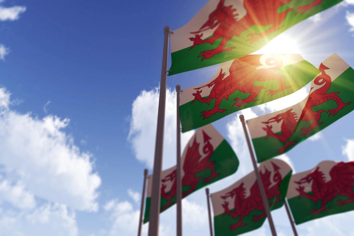 wales-flags-waving-wind-against-blue-sky