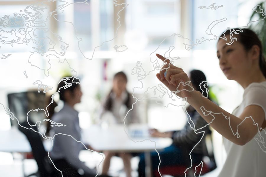 a lady pointing to a world map