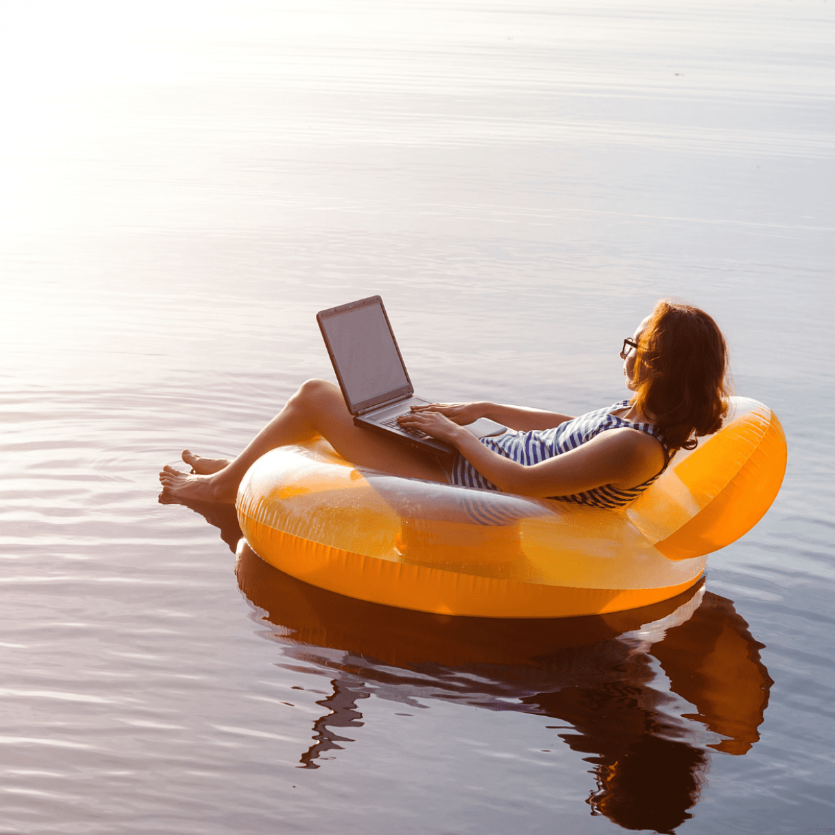 Woman on a Floatie working from her Laptop