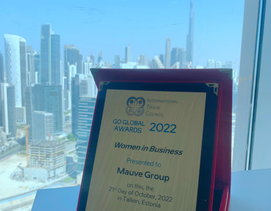 a plaque for the 2022 GO Global Awards for Women in Business, presented to Mauve Group on October 27, 2022, in Tallinn, Estonia. The award is displayed in a red velvet-lined box with a city skyline in the background