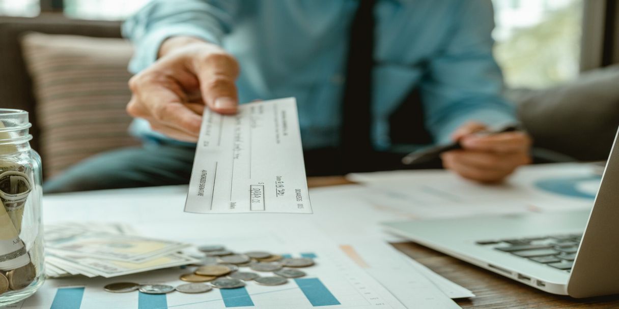 13th month pay cheque being handed across a desk