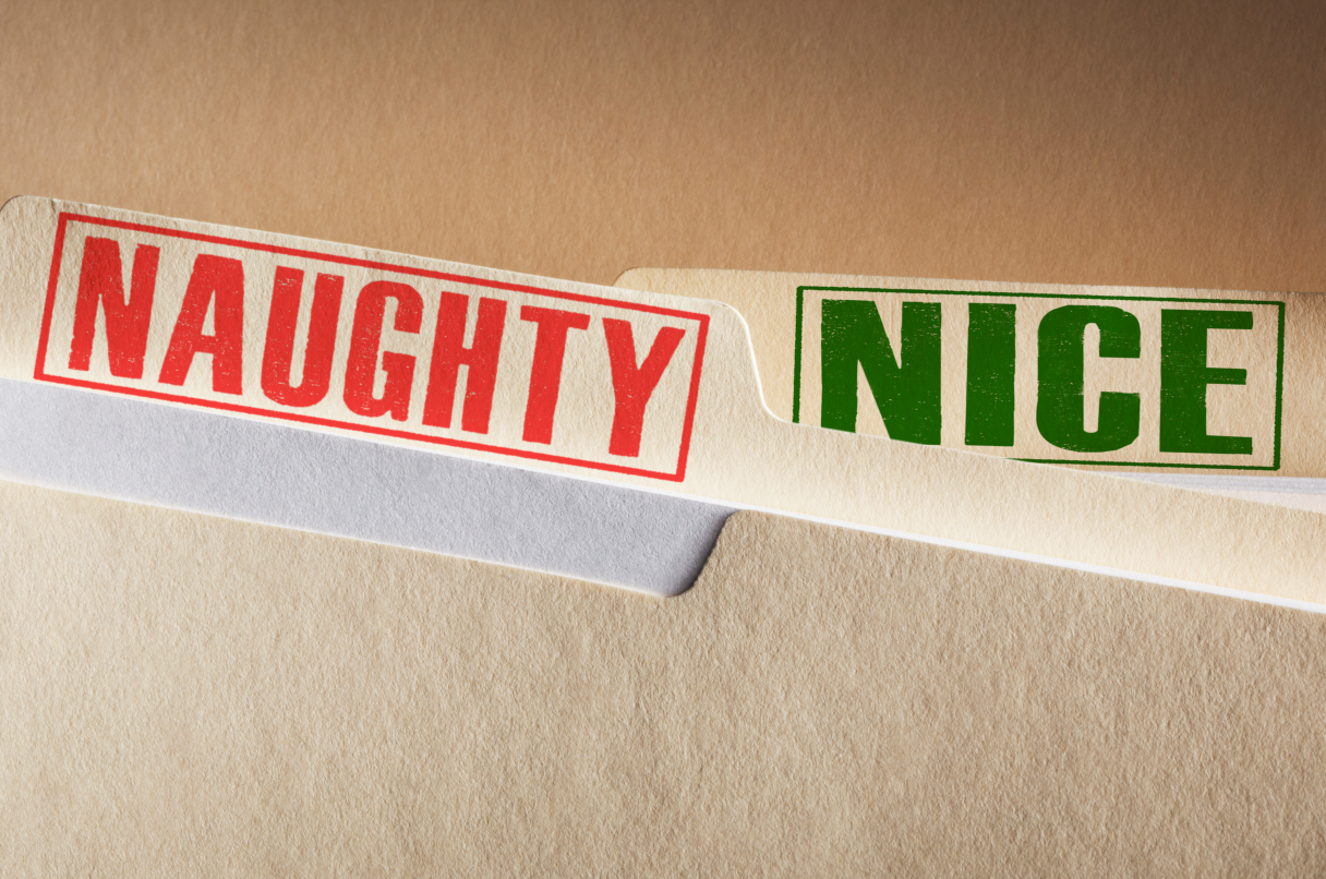 A close-up of a file folder with tabs titled 'Naughty' in red and 'Nice' in green