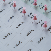 A calendar with pink push pins