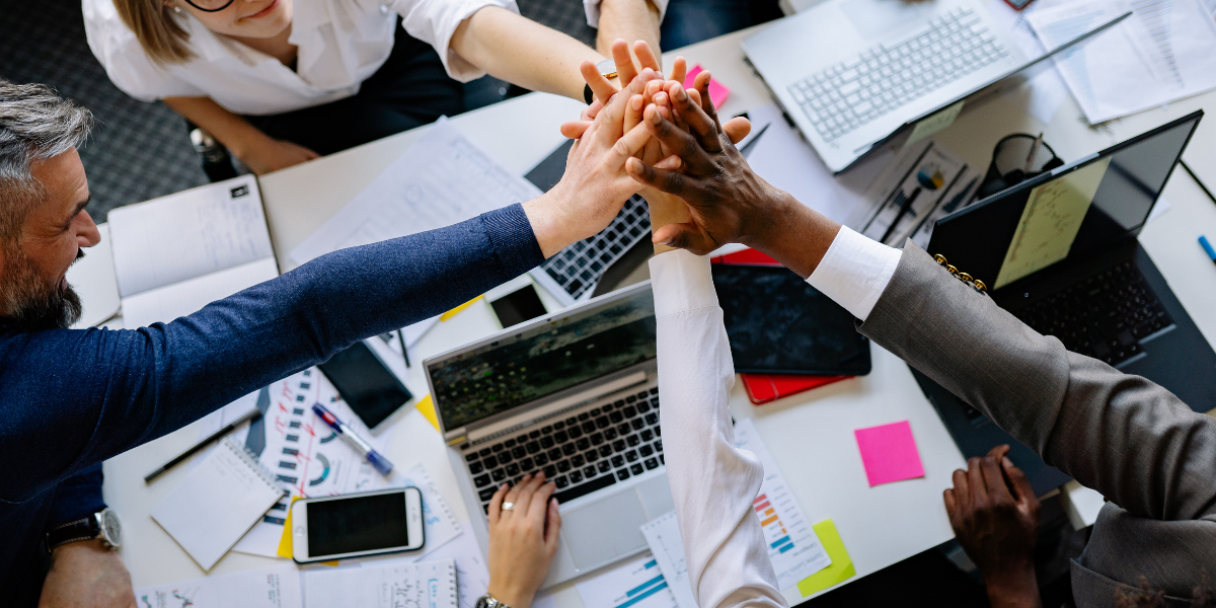 Colleagues high-fiving in a meeting