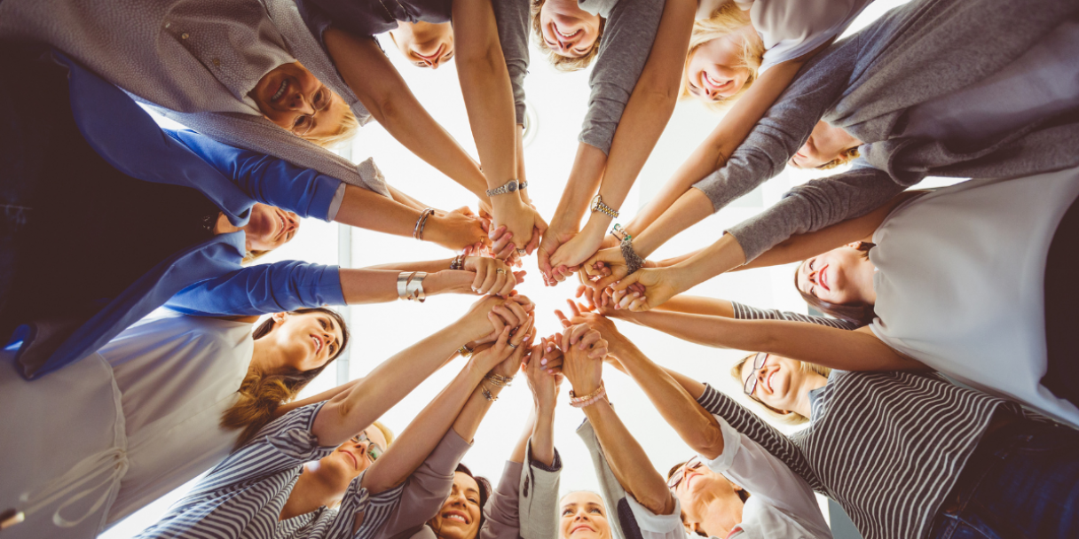 a team of women huddled in a circle