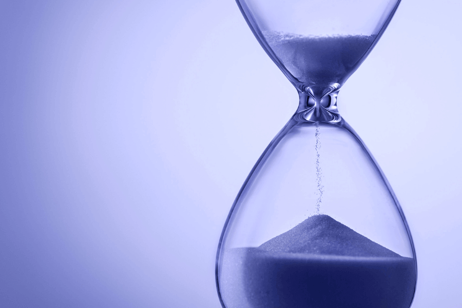 Purple-blue hourglass filled with sand