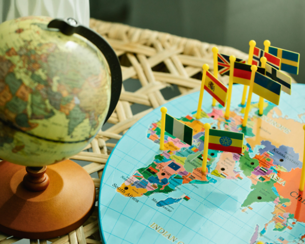 flags pinpointing countries on a board of the world map