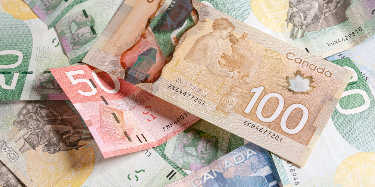 A pile of Canadian banknotes including $100, $50, and $20 denominations.