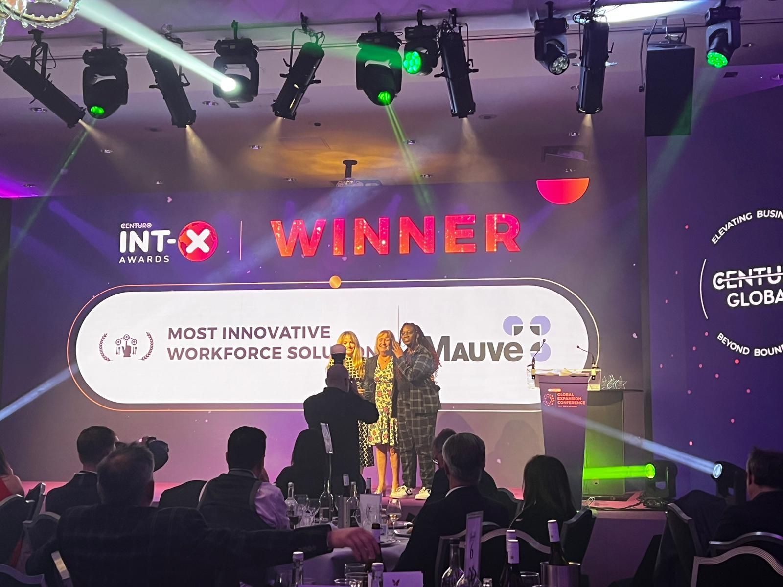 the mauve team on stage collecting its INT-x award 2023