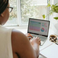 An over-the-shoulder look at a woman working at her desk