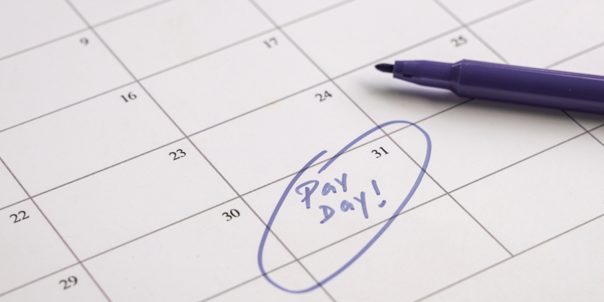 the words 'pay day' circled in purple felt pen on a calendar