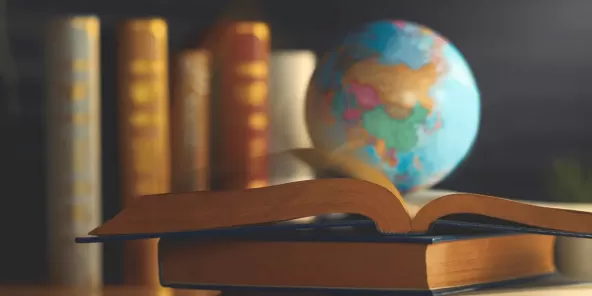a globe atop a stack of books