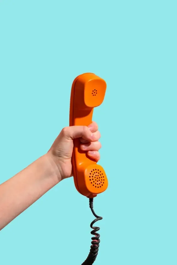 A hand holding a red phone against a neon blue background