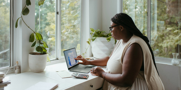 a woman working on her laptop in front of a window