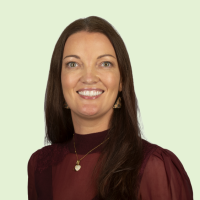 headshot of Annette Ord smiling against a green background