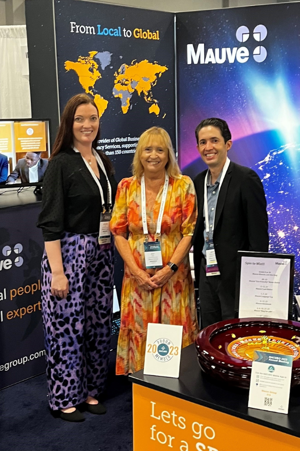 team Mauve Group standing at their NACUBO booth in 2023