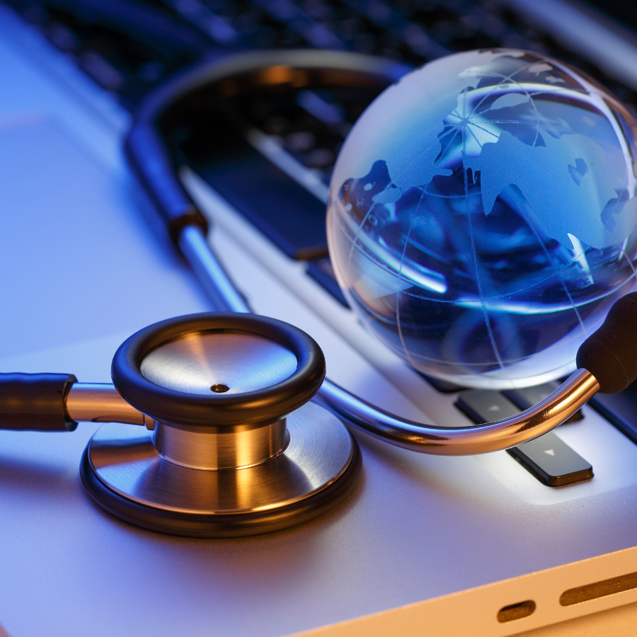 A globe and stethoscope atop a laptop keyboard