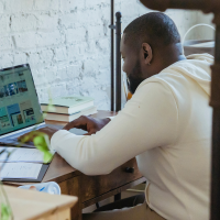 Black man typing on laptop