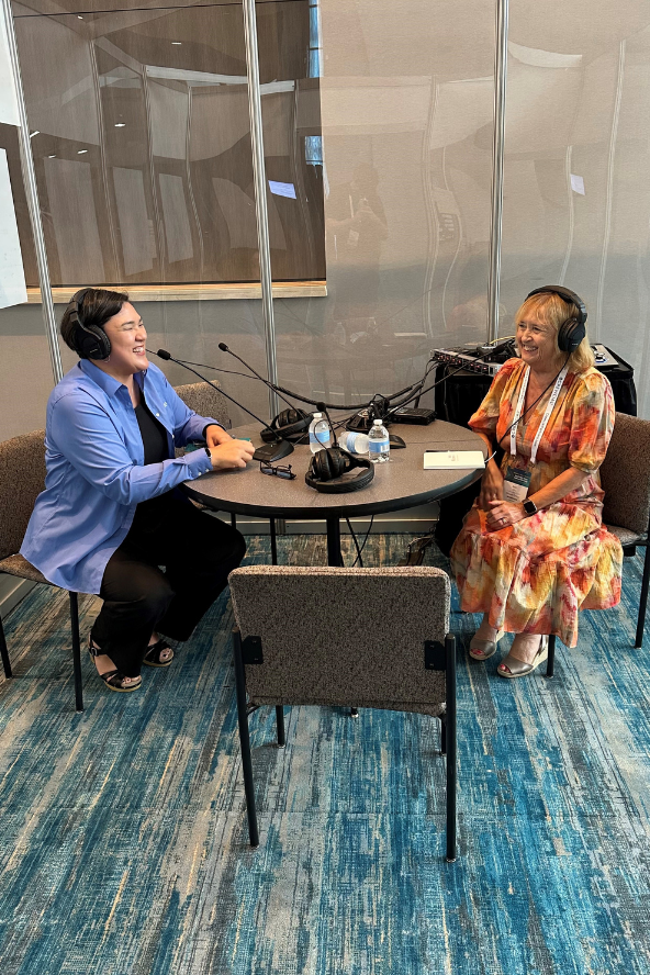 Ann wearing headphones sat in a booth while recording her episode of Nacubo's podcast.