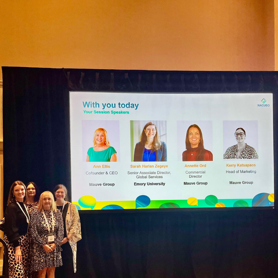 member of Mauve's team pause in front of a screen, ahead of a panel talk with Emory University at NACUBO