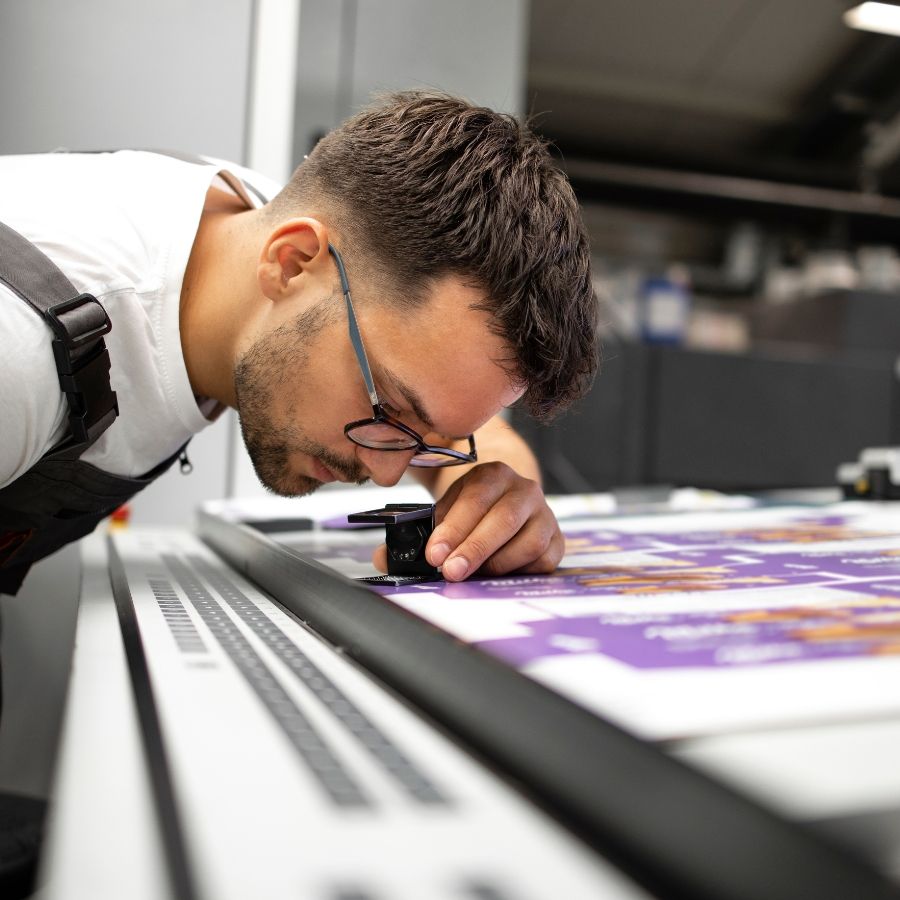 male worker checking print quality of graphics