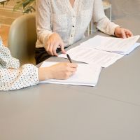 Mujeres discutiendo documentos oficiales y tomando notas